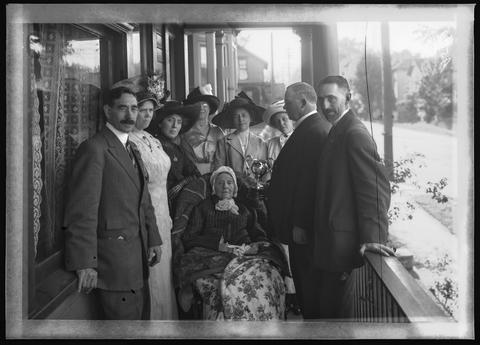 Mary Cachot Therkelsen is the third person standing on the left with her arm resting on Dunway's chair.