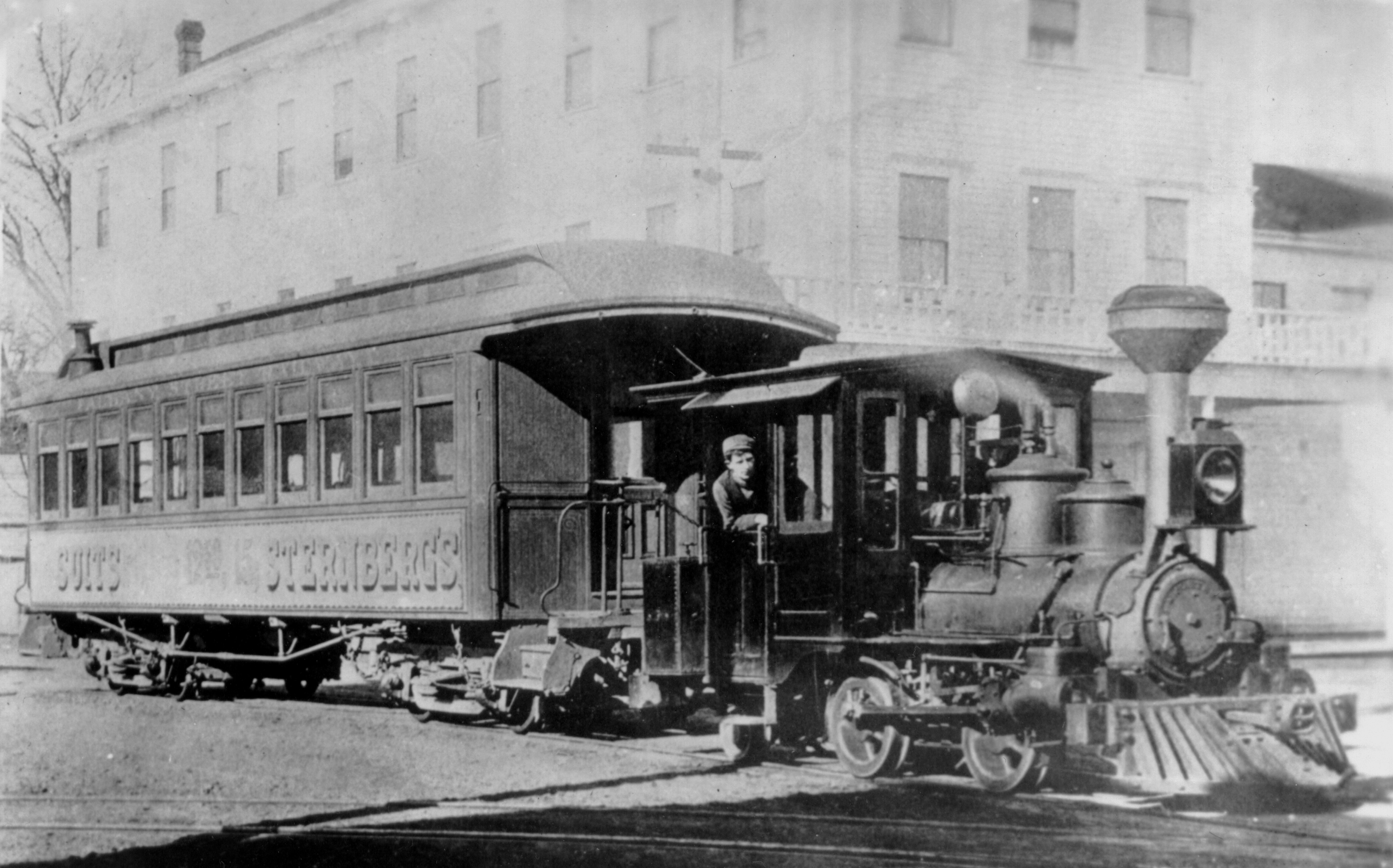 Porter steam "dinky" locomotive and railroad coach in front of St. Charles Hotel on 1st and Washington Sts., about 1900.