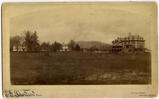Students stand in the grass between Herrick Hall and Old College and Academy Halls.