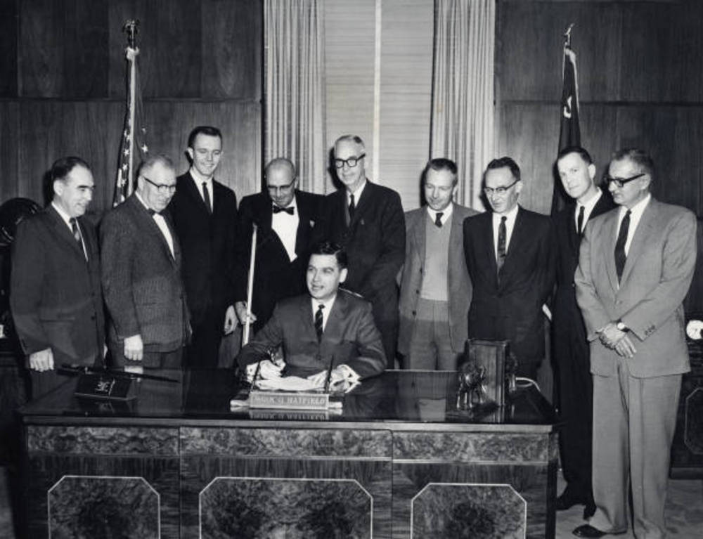 Govenor Mark O. Hatfield signs legislation changing the name of Oregon State College to Oregon State University, March 1961.