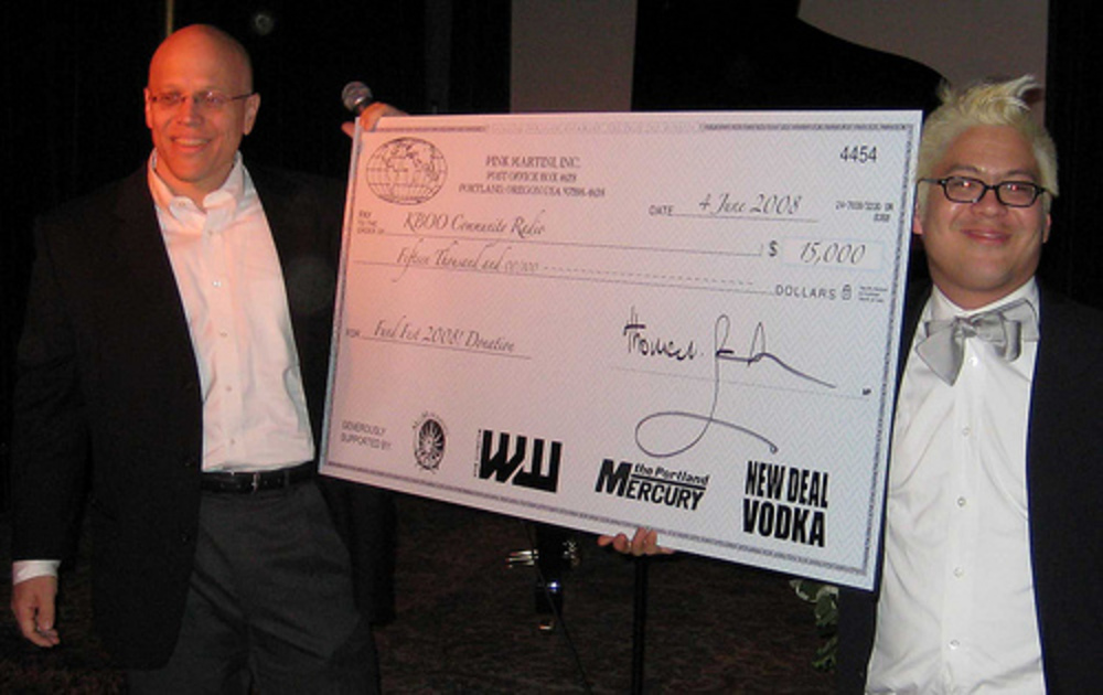 Thomas Lauderdale of Pink Martini (right) presents fundfest check to KBOO station manager Arthur Davis.