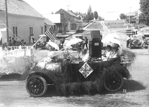 Reed Brothers Rexall Drug automobile float rolls down Broadway Avenue in 1915 c. parade.