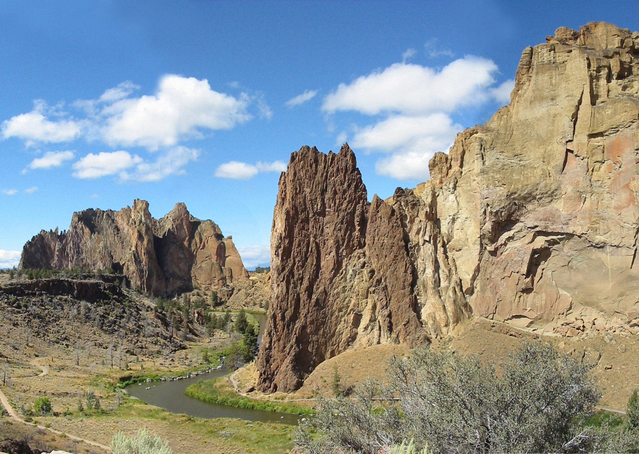Rhyolite dike intruding tuff of Smith Rock on Crooked River. Basalt flow from Newberry Volcano forming ledges on the east side.