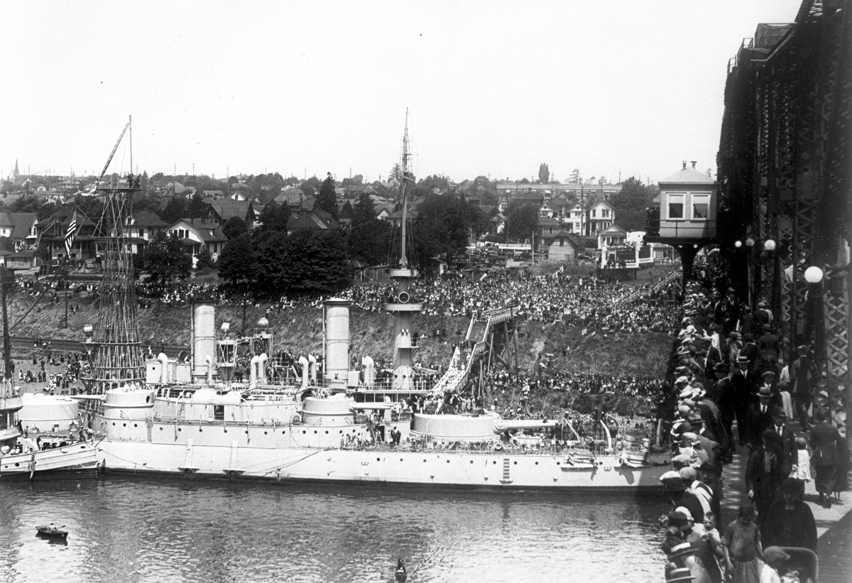 Crowds greet U.S.S. Oregon at ship's first moorage in Portland at NE end of Broadway Bridge, June 1925.