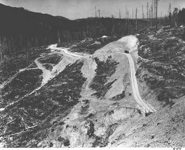 Road construction at the Wilson River cutoff in Tillamook County. The view is east from a railroad trestle and shows an area of forest burned in the Tillamook Burns, a series of devastating forest fires in Tillamook County in 1933 and 1939.