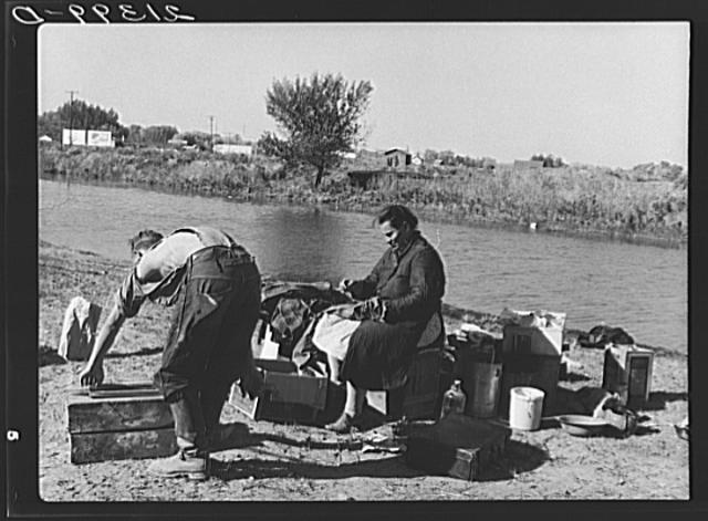 Migrant family cleaning up camp.