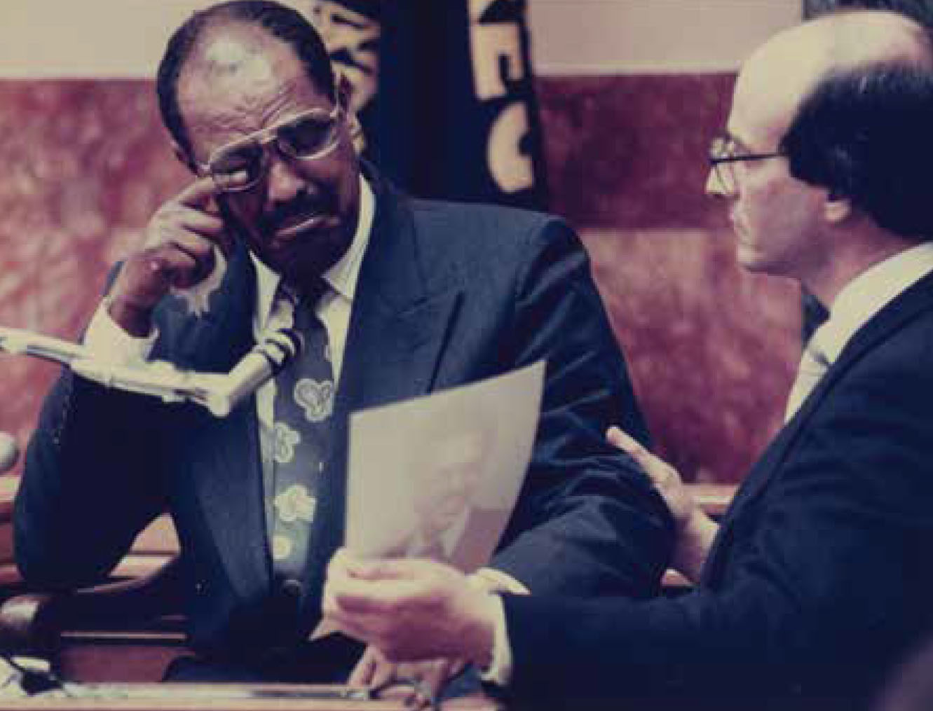 Elden Rosenthal shows Berhanu a photograph of Mulugeta Seraw as Berhanu wipes tears from his eye.